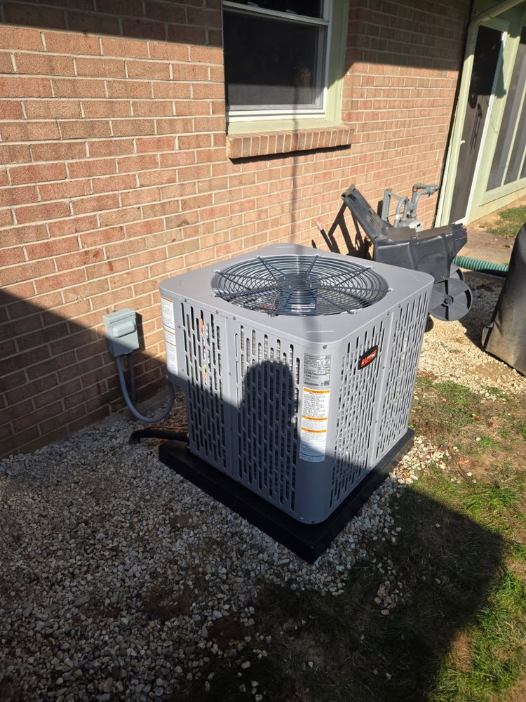 Outdoor central AC condenser installed beside a brick home in Anderson, Indiana
